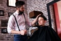 Hairdresser adjusts hair a customer with a comb Royalty Free Stock Photo