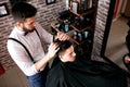 Hairdresser adjusts hair a customer with a comb Royalty Free Stock Photo