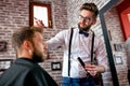 Hairdresser adjusts hair a customer with a comb Royalty Free Stock Photo