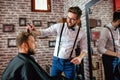 Hairdresser adjusts hair a customer with a comb Royalty Free Stock Photo