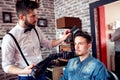 Hairdresser adjusts hair a customer with a comb Royalty Free Stock Photo