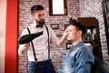 Hairdresser adjusts hair a customer with a comb Royalty Free Stock Photo