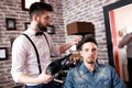 Hairdresser adjusts hair a customer with a comb Royalty Free Stock Photo