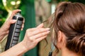 Hairdresser applying hair spray on hair