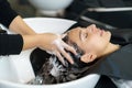 Hairdresser is applying shampoo and massaging hair of a customer. Woman having her hair washed in a hairdressing salon Royalty Free Stock Photo