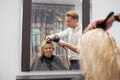 Hairdresser blow drying client's hair Royalty Free Stock Photo