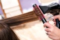 Hairdresser blow drying long brown hair