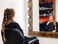Hairdresser braiding woman`s hair in hairdressing salon Royalty Free Stock Photo