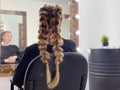 Hairdresser braiding woman`s hair in hairdressing salon Royalty Free Stock Photo