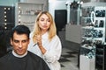 Hairdresser bringing scissors close to customer head