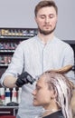 A hairdresser coloring hair of a blonde female client Royalty Free Stock Photo