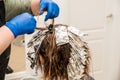 Hairdresser coloring hair in studio. highlighting or coloring of red hair Royalty Free Stock Photo