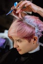 Hairdresser colorist dyes the hair of a woman to a client in different colors.