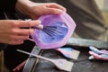 Hairdresser colorist kneads paint for hair dyeing.