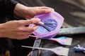 Hairdresser colorist kneads paint for hair dyeing.