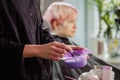 Hairdresser colorist kneads paint for hair dyeing.