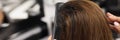 Hairdresser combing long hair of client in beauty salon closeup Royalty Free Stock Photo