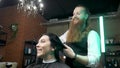 Hairdresser combs a woman