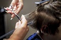 hairdresser creates a fashionable haircut for a tenager boy