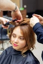 Hairdresser curling long light brown hair