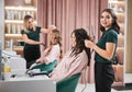 Hairdresser curling woman hair in beauty salon. Royalty Free Stock Photo