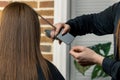 Hairdresser cuts out a girl with long brown hair