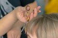 A hairdresser cuts women`s hair with scissors in a spa salon