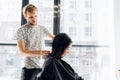 Hairdresser cutting client`s hair in salon with scissors closeup. Using a comb Royalty Free Stock Photo