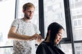 Hairdresser cutting client`s hair in salon with scissors closeup. Using a comb Royalty Free Stock Photo