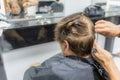 Hairdresser cutting the hair of an elderly woman, reflected in the mirror on a blurred background Royalty Free Stock Photo