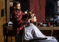 Hairdresser cutting hair of male client. Hairstylist serving client at barber shop. Man visiting hairstylist in Royalty Free Stock Photo