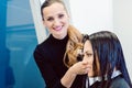 Hairdresser cutting and styling hair of woman in her shop Royalty Free Stock Photo