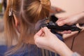 The hairdresser does hair extensions to a young girl, a blonde in a beauty salon. Royalty Free Stock Photo