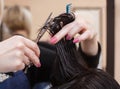 The hairdresser does a haircut with hot scissors of hair to a young girl, a brunette Royalty Free Stock Photo