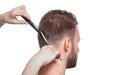 A hairdresser does a haircut for a young man in a barbershop