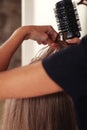 Hairdresser does hairstyle cute young woman in beauty salon Royalty Free Stock Photo