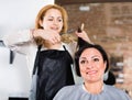 Hairdresser does to woman haircut with use of scissors and hairbrushes Royalty Free Stock Photo