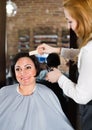 Hairdresser does to woman haircut with use of scissors and hairbrushes Royalty Free Stock Photo