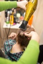 Hairdresser dries the hair dryer blond hair