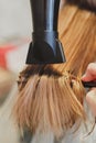 Hairdresser dries hair the girl blonde