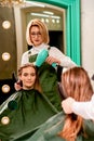 The hairdresser dries hair with a hairdryer of the beautiful young caucasian woman in the beauty salon. Royalty Free Stock Photo