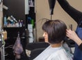 Hairdresser dries her hair a brunette girl in a beauty salon.