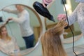 hairdresser drying female clients wet hair in salon