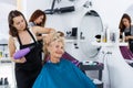 Hairdresser drying hair of elderly female