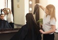 Hairdresser drying long brown hair with hair-drier