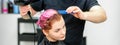 A hairdresser is drying the pink hair of the young woman in a beauty salon. Royalty Free Stock Photo