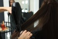 Hairdresser drying woman`s hair in beauty salon, closeup Royalty Free Stock Photo