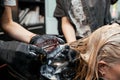 Hairdresser dyes hair in a professional salon. close-up of hands.