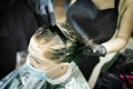 Hairdresser dyes woman hair