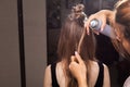 Hairdresser fixing a hairstrand of a model with a hairspray Royalty Free Stock Photo